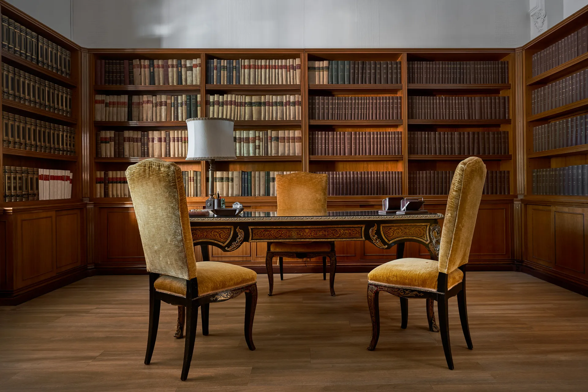 La biblioteca del Palazzo con scaffali in legno e scrivania intarsiata