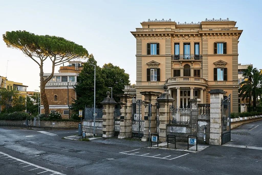 Il Palazzo visto dalla strada di giorno, tra i pini