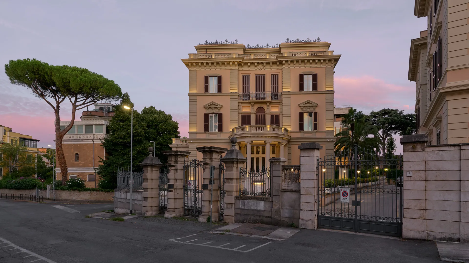 Il Palazzo visto dalla strada, tra i pini e le palme